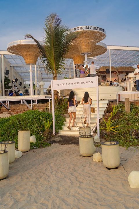 Entrance stairs from the beach with venue signage at Morjim Culture