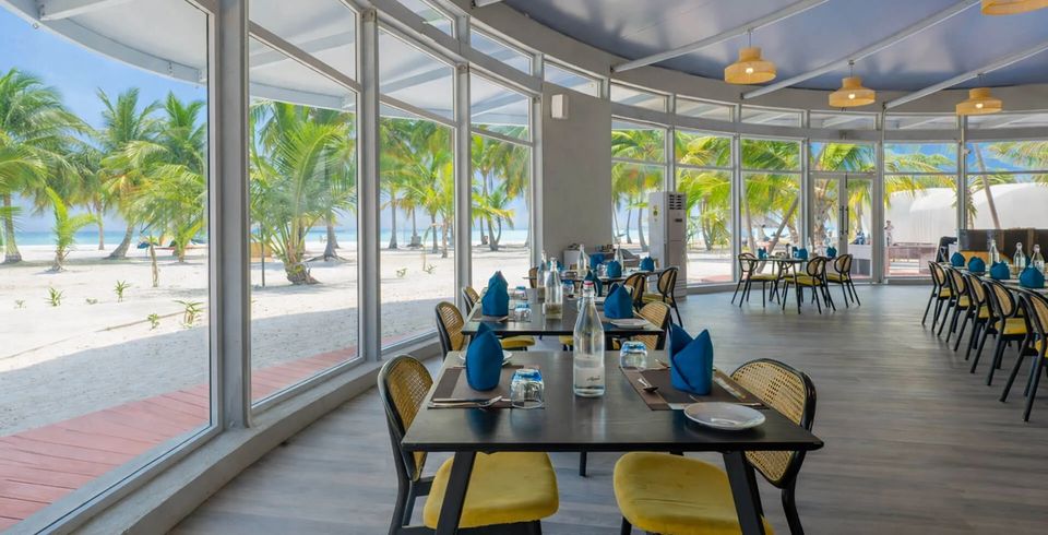 Restaurant tables behind beach-facing glass walls