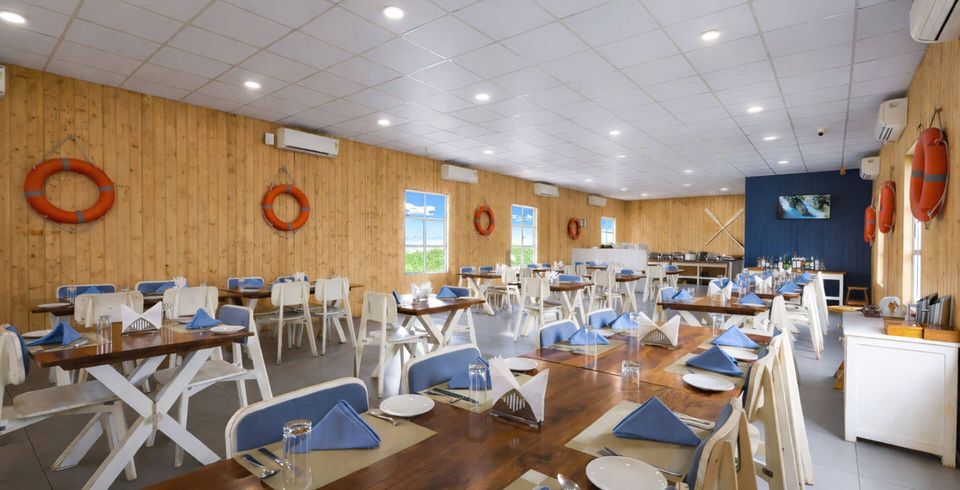 Restaurant tables arranged beneath a high ceiling