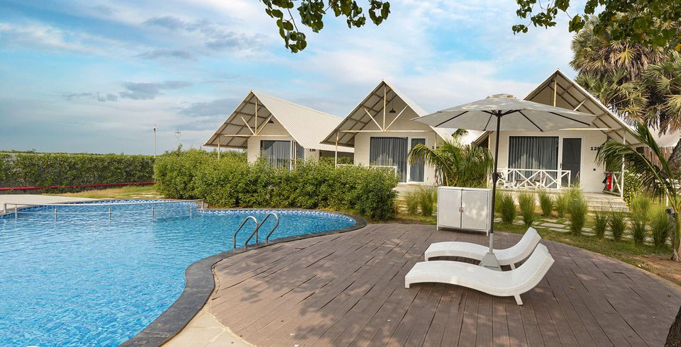 Pool and sun loungers facing cottage gardens