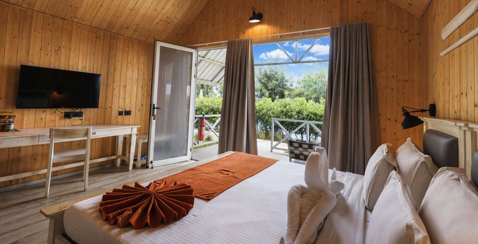 Timber cottage bedroom opening onto gardens