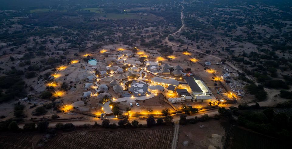 Resort buildings illuminated across the Jawai landscape