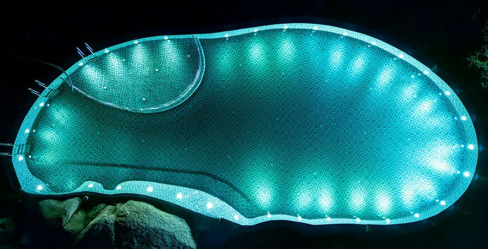 Curving swimming pool illuminated at night