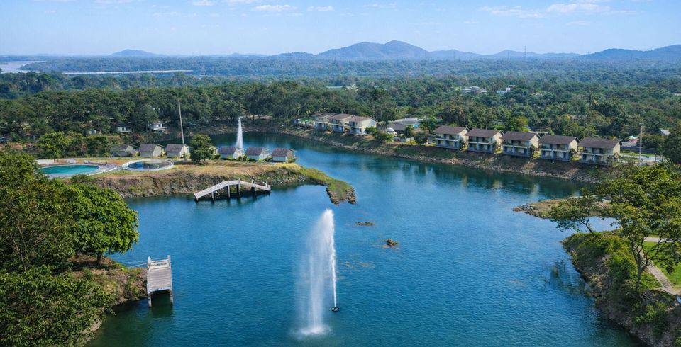 Aerial view of a lake and fountain beside cottages