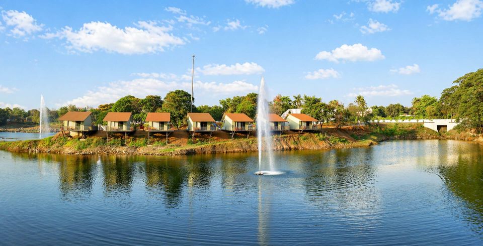 Cottages reflected in a lake around a fountain