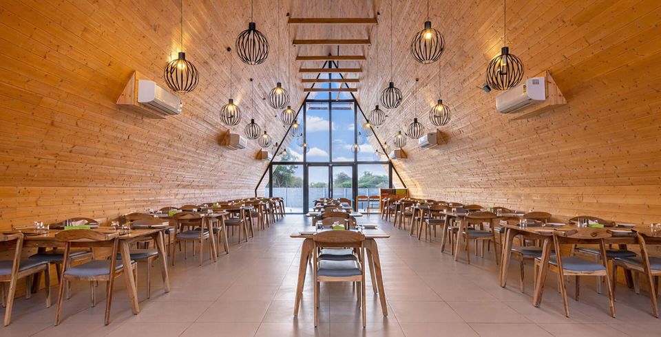 Wood-lined restaurant beneath a triangular window