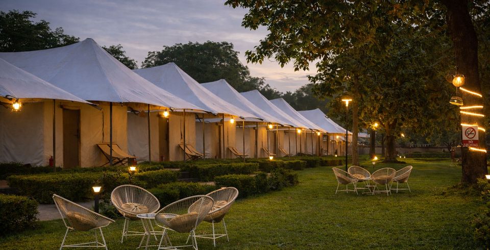 Lit tents and garden seating at dusk