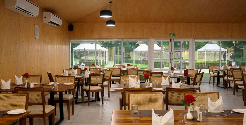 Restaurant tables beside garden-facing windows