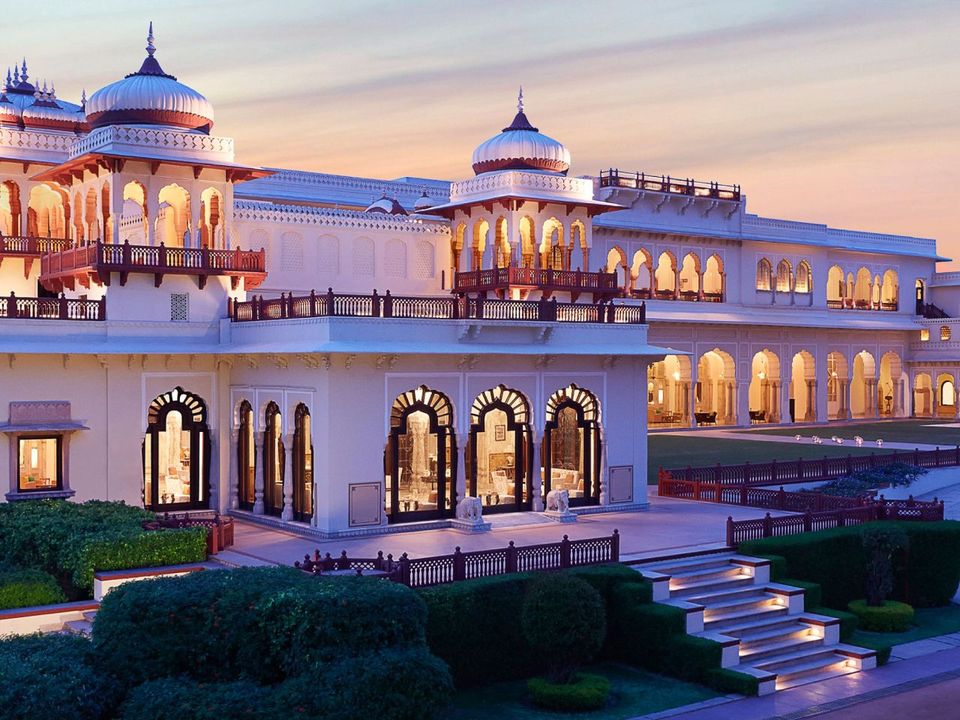 Illuminated palace facade and formal gardens at dusk