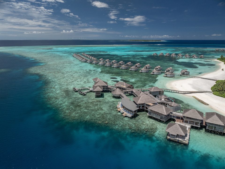 Overwater villas extending across a turquoise lagoon