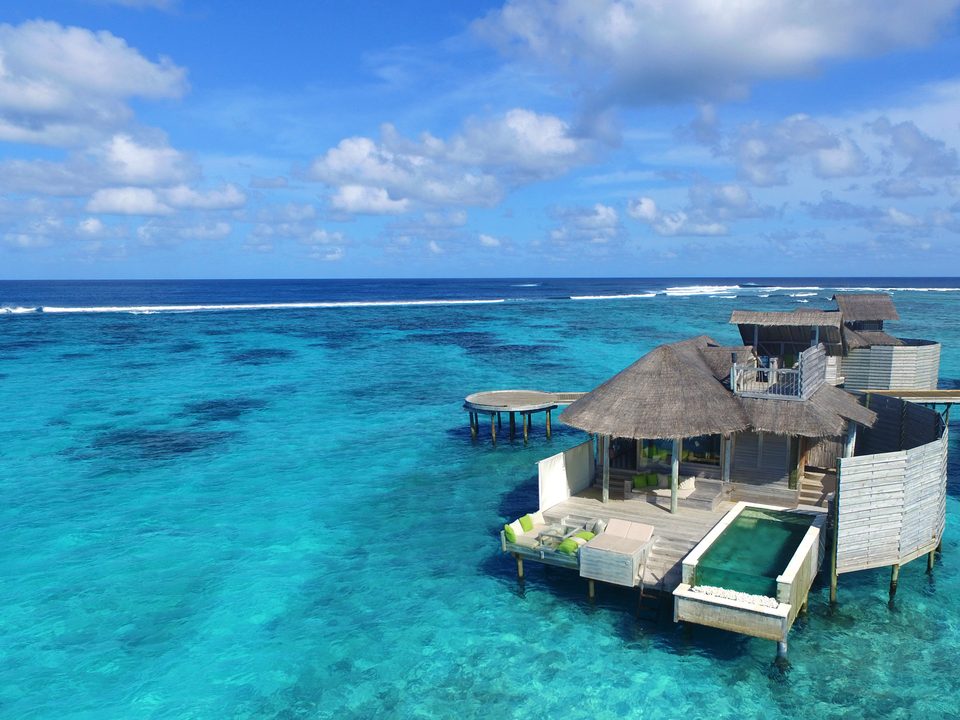 Overwater villa with private pool above clear water