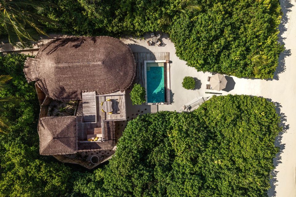 Aerial view of a beach villa surrounded by palms