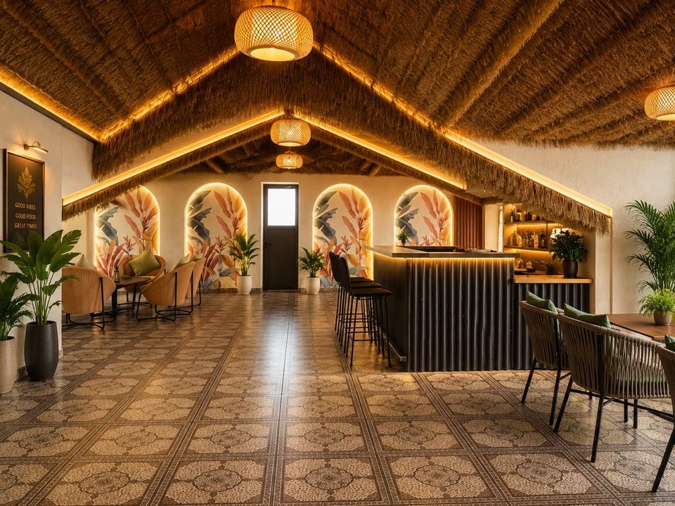 Aqua rooftop lounge and bar with a thatched ceiling and rattan lights at Solace Suites