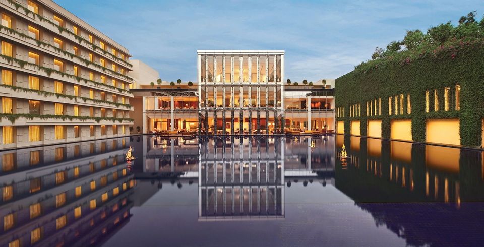 Hotel buildings reflected in a broad pool at dusk