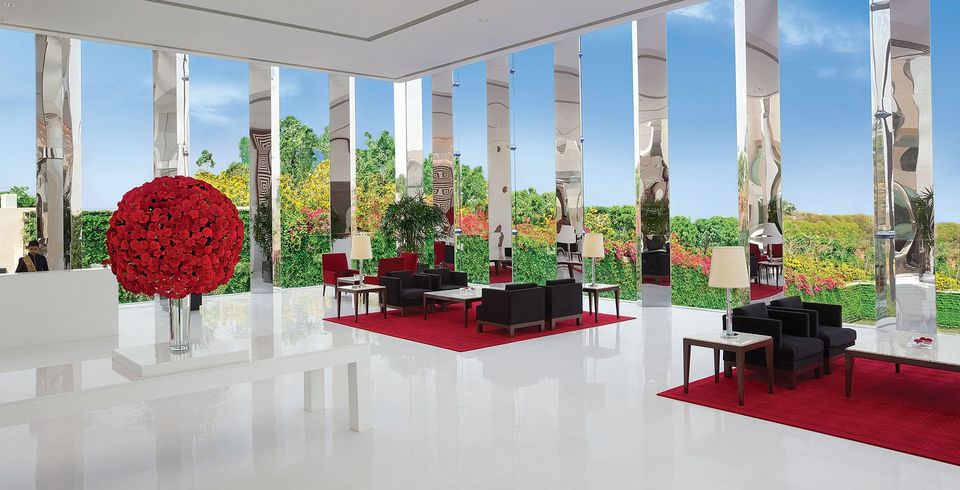 Bright marble lobby with red flower arrangements and seating