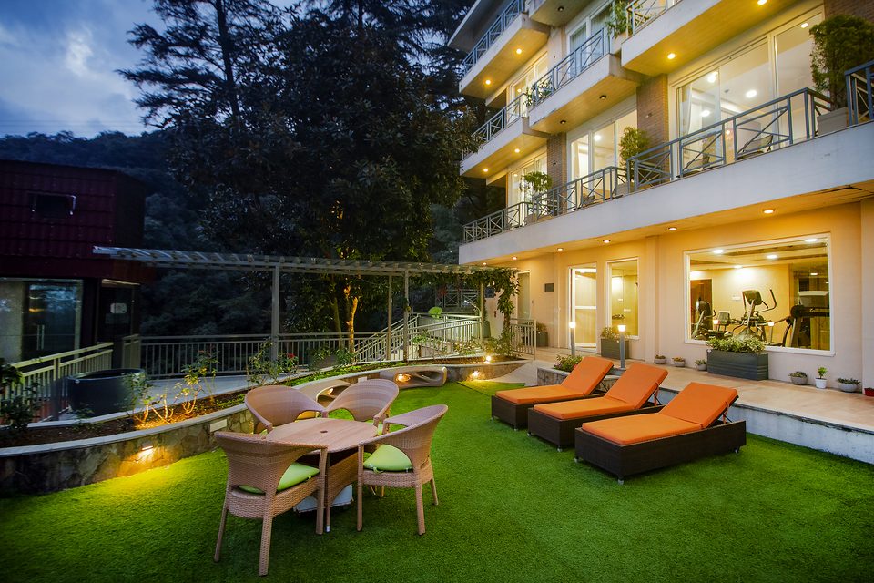 Illuminated resort facade and garden at dusk